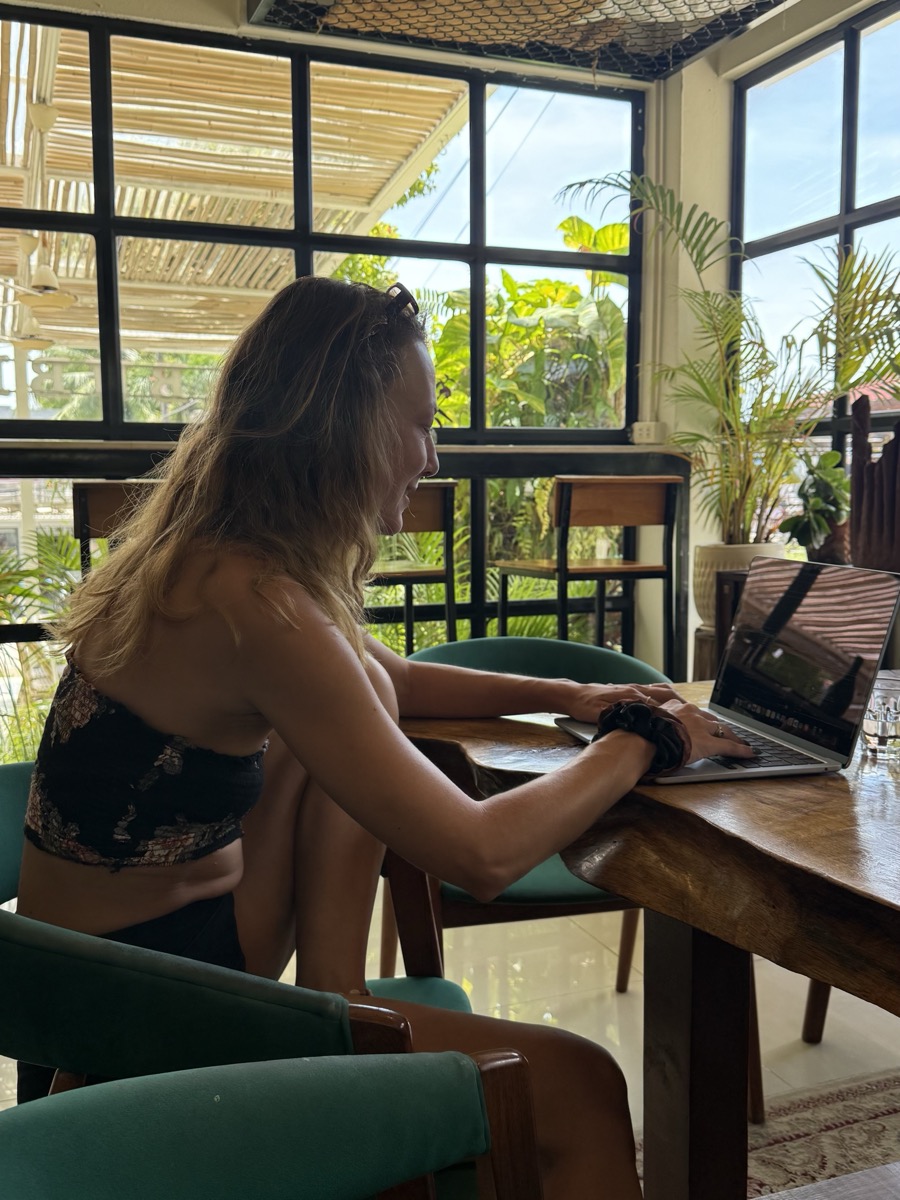 Sarah Kehm working on her laptop in a tropical co-working space on Koh Phangan, Thailand